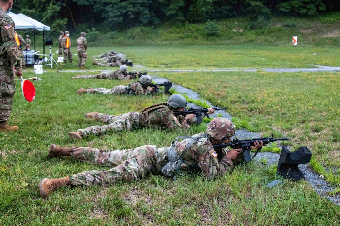 Guardsmen lay on the ground holding weapons.