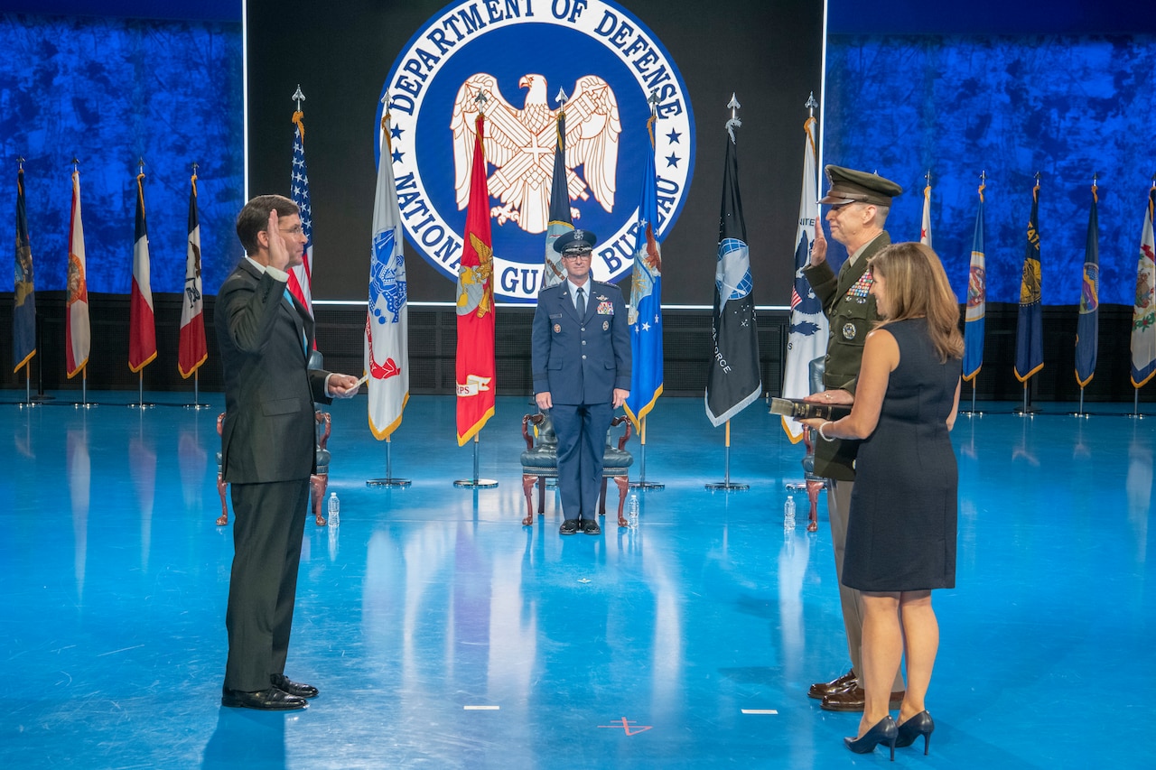 Defense Secretary Dr. Mark T. Esper holds up his right hand facing Army Lt. Gen. Daniel R. Hokanson who is also raising his right hand.