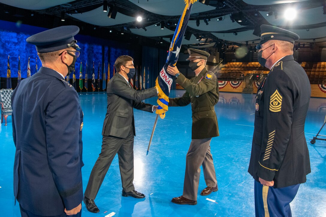 Defense Secretary Dr. Mark T. Esper hands a flag to Army Lt. Gen. Daniel R. Hokanson; others stand around.