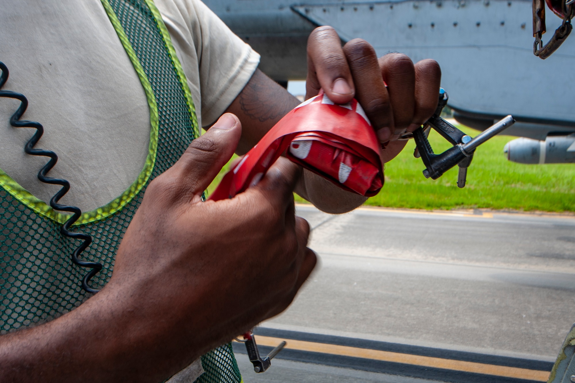 A photo of an Airman rolling up a safety tag.