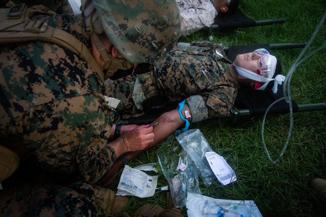 A Navy corpsman with Combat Logistic Battalion (CLB) 31, 31st Marine Expeditionary Unit (MEU), inserts an intravenous therapy into a simulated combat casualty during a nightingale exercise at Camp Hansen, Okinawa, Japan.