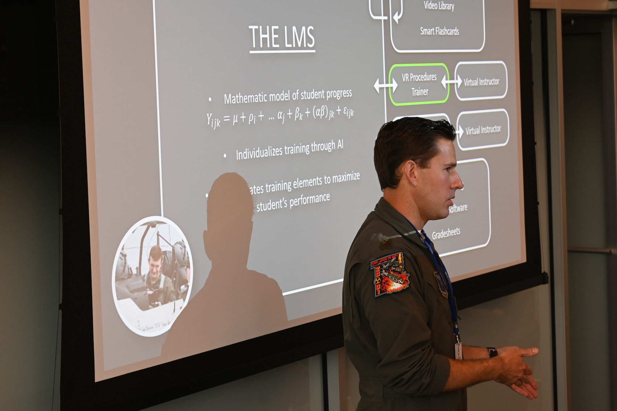 Airman gives a speech in front of a power point presentation.