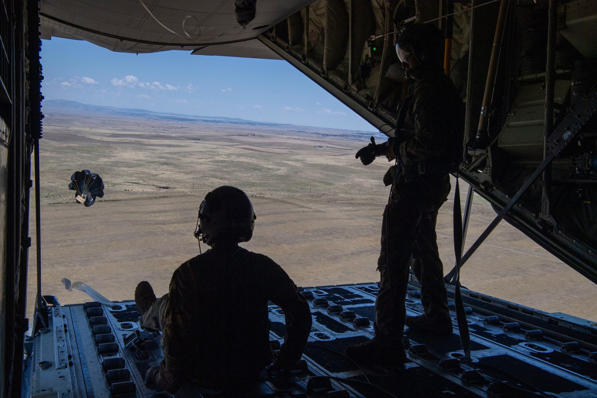 Airman 1st Class Cameron Bou (left) and Senior Airman Kirk Mumau (right), 41st Airlift Squadron loadmasters, conduct an airdrop over Reed Drop Zone in Colorado July 27, 2020. This training is part of the 4/12 deployment initiative, which was developed in 2019 between airlift squadrons from Dyess Air Force Base, Texas and Little Rock AFB, allowing each squadron a full year of dwell time followed by a four-month rotation to their respective area of responsibility. (U.S. Air Force photo by Airman 1st Class Aaron Irvin)