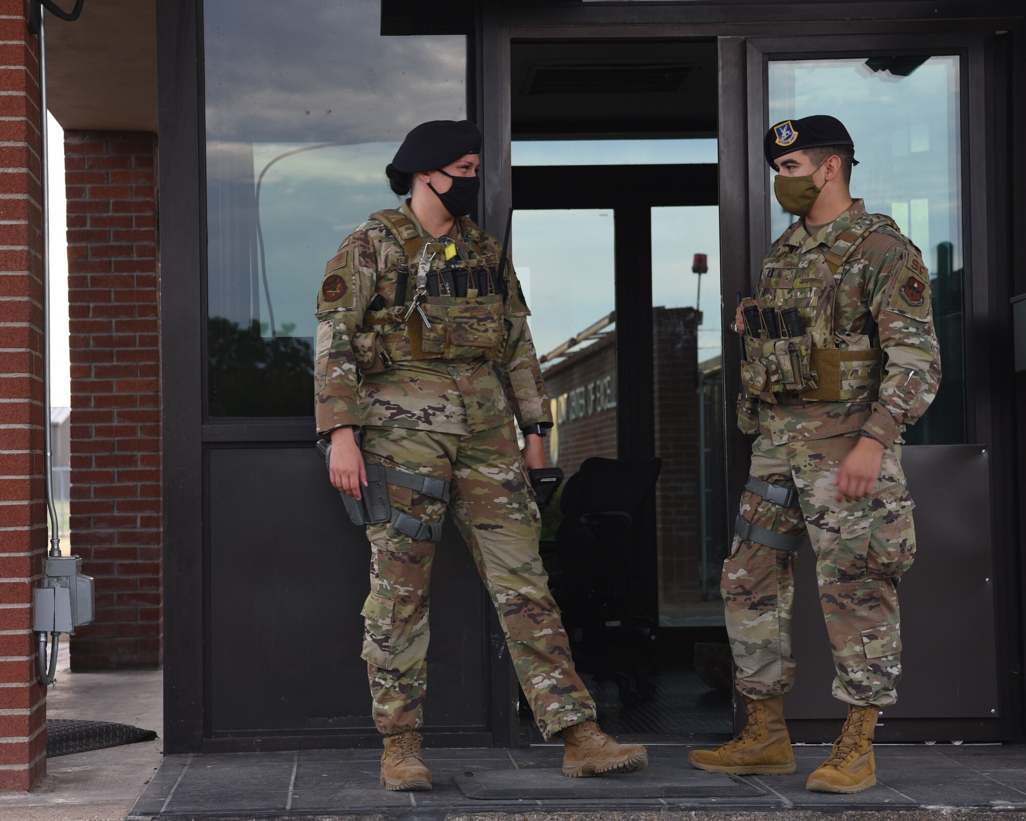 U.S. Air Force Airman 1st Class Erin Kenny, 17th Security Forces Squadron patrolman, builds workplace comradery with Airman Christopher Garza, 17th SFS installation entry controller, during down time when waiting for approaching vehicles at the North Gate on Goodfellow Air Force Base, Texas, Aug. 3, 2020.  The installation commander enforced stay-at-home orders, a travel ban, and leave restrictions for Air Force members in correlation to the COVID-19 pandemic. (U.S. Air Force photo by Airman 1st Class Abbey Rieves)