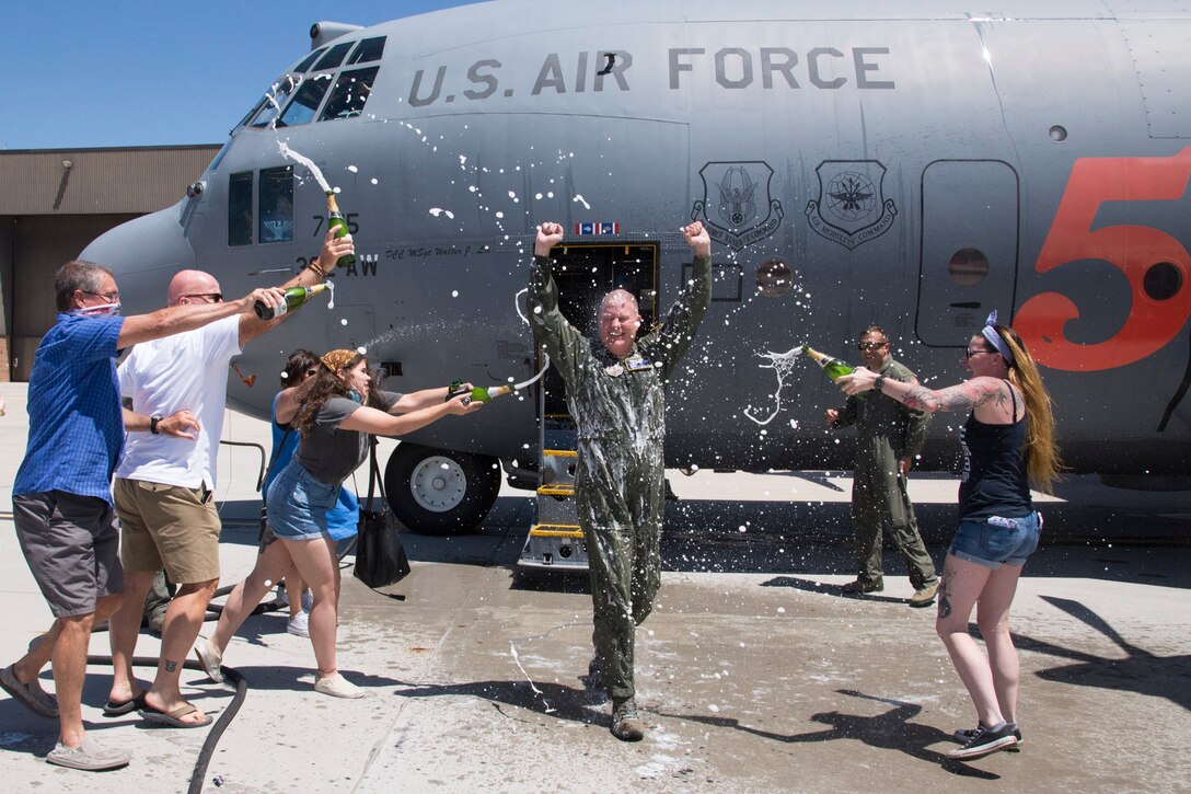 Col. James DeVere, 302nd Airlift Wing commander, steps out of a C-130 aircraft to celebrate with friends and family after his final flight as an Air Force pilot