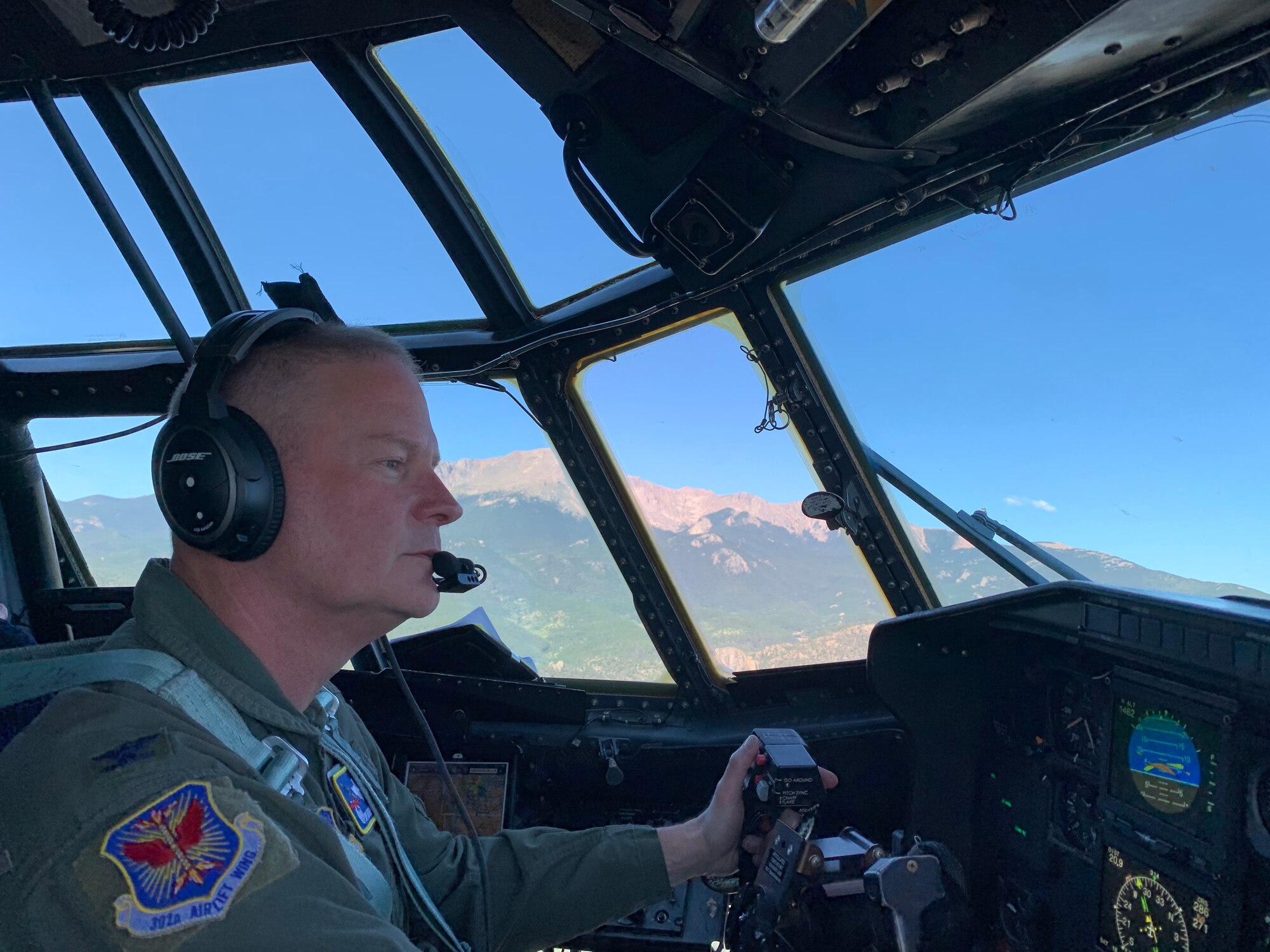 Col. James DeVere, 302nd Airlift Wing commander, flies a C-130 aircraft for the last time as an Air Force pilot over Colorado with Pikes Peak in the background