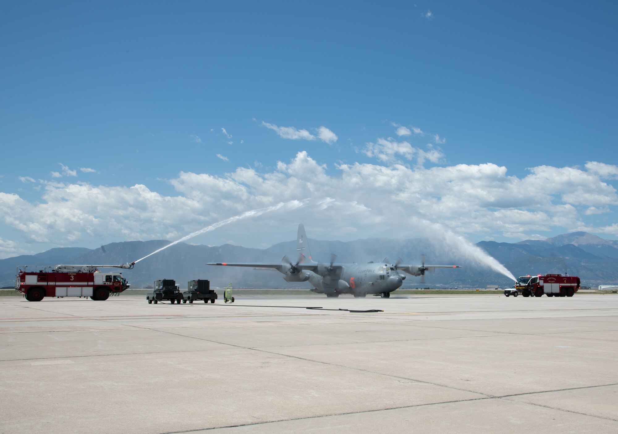 A C-130 Hercules navigated by Col. James DeVere goes under a water archway provided by the 21st Space Wing.