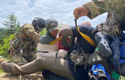 Washington Army National Guard helicopter crew members from Charlie Company, 1st Battalion, 140th Aviation, assist 2nd Lt. Darien Konzelman, 194th Intelligence Squadron, with an injured hiker Aug. 2, 2020, near Packwood, Wash. Konzelman was bear hunting with friends when rockslides injured Konzelman and other hikers.