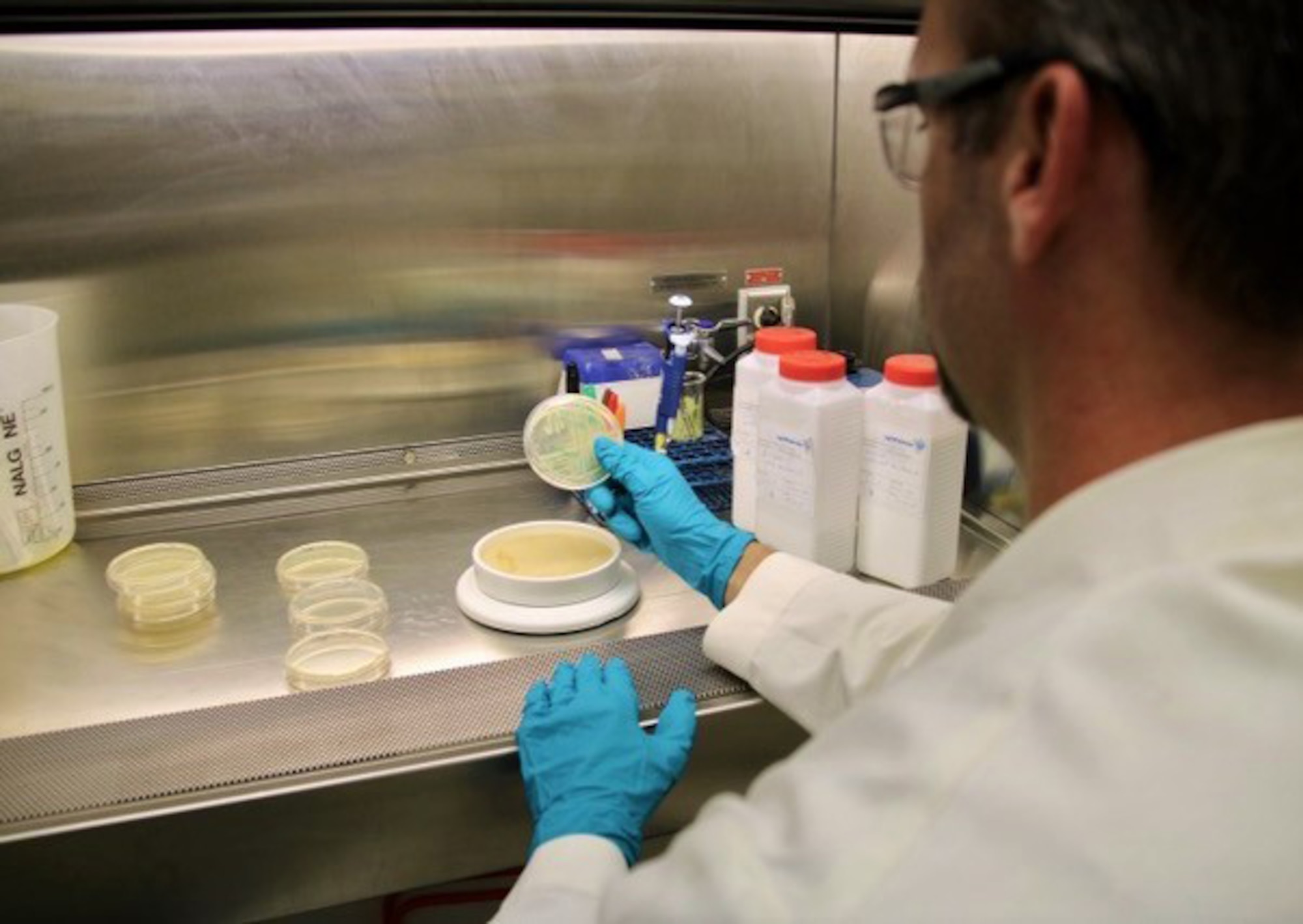 Lab technician holds a sample showing reaction to patented formula.