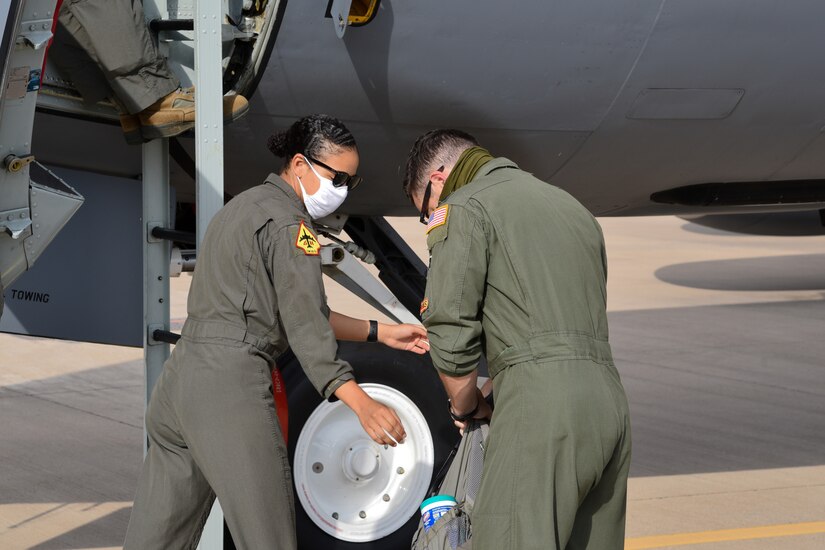 Pilots wearing face masks prepare to board a tanker aircraft.
