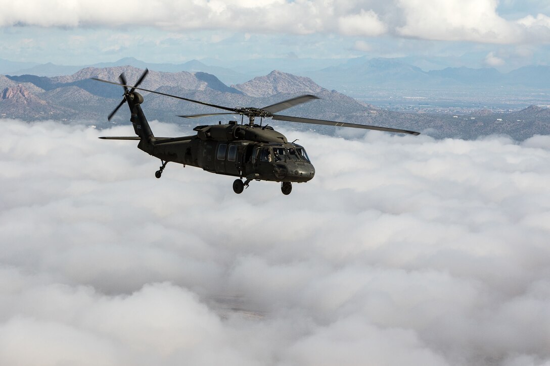 An Arizona Army National Guard UH-60 Black Hawk helicopter with 2-285th Assualt Helicopter Battalion in Phoenix soars over a low layer of clouds during a flight to the Western Army Aviation Training site in Marana, Ariz. March 4, 2015.