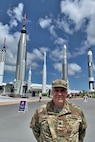 U.S. Army Reserve Lt. Col. Pat Lis stands in front of the “Rocket Garden” attraction at the Kennedy Space Center Visitor Complex in Florida. The Rocket Garden represents rockets from NASA’s Mercury, Gemini and Apollo programs including; the Saturn 1B, Delta, Juno I, Juno II, Gemini-Titan II, Mercury-Redstone and Mercury-Atlas rockets.