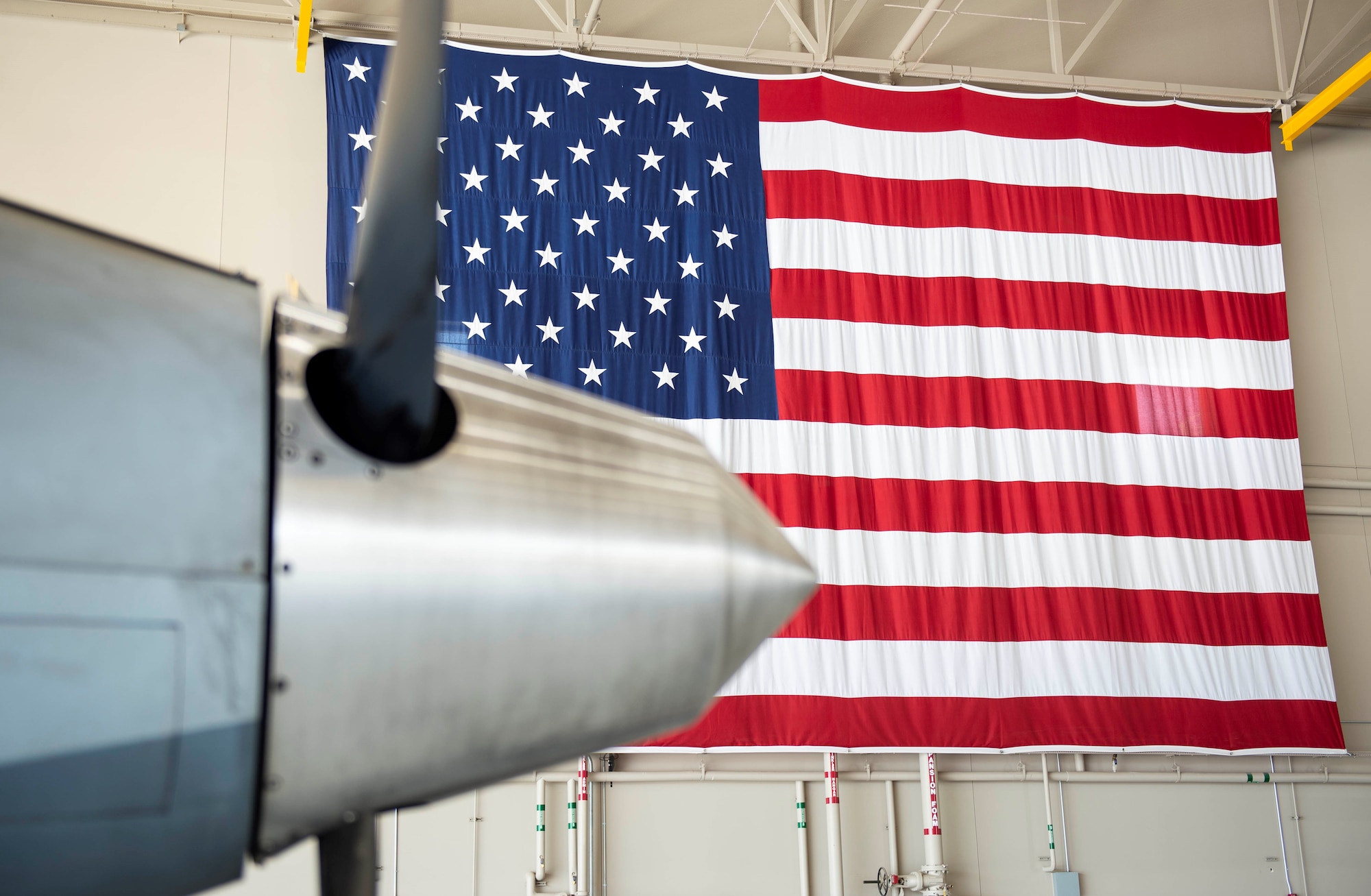 An American Flag sits in the back drop of an MQ-9 Reaper propeller.