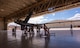 An MQ-9 Reaper sits in a hangar with 5 members preparing to conduct routine maintenance.