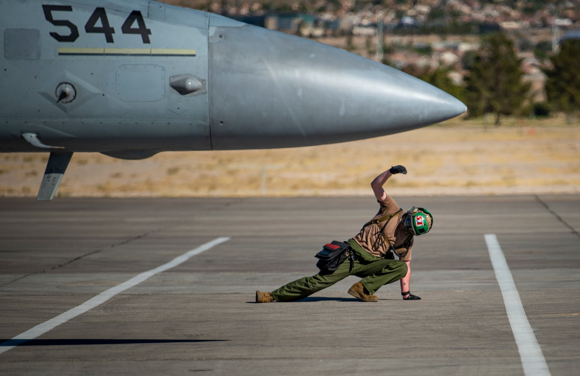 Airman signals plane on the flight line.