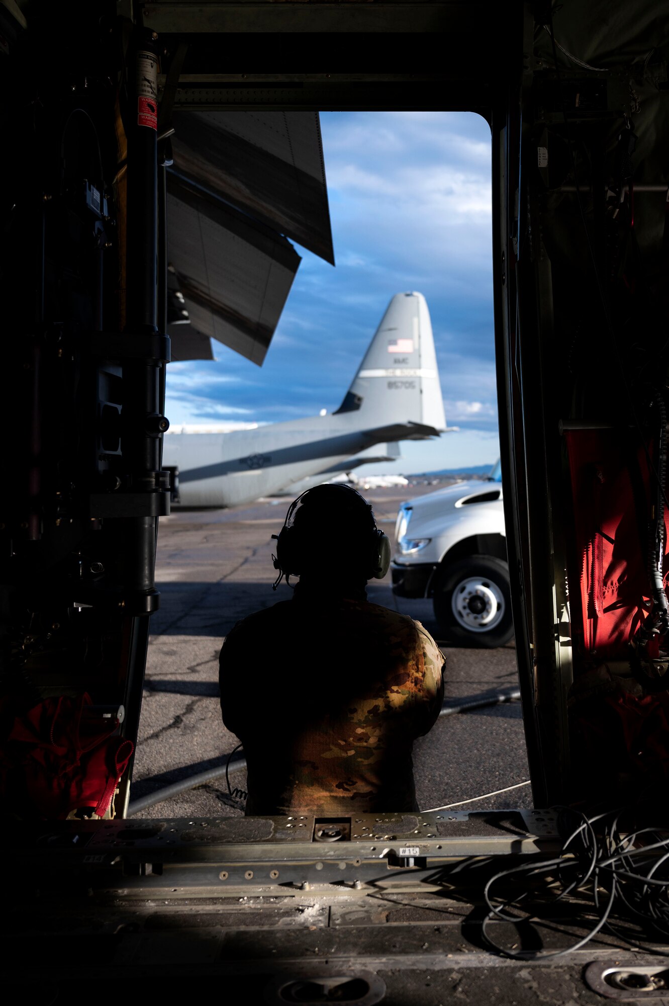 An Airman assigned to the 19th Airlift Wing, waits for a worker at Montrose Regional Airport to finish fueling a C-130J Super Hercules in Montrose, Colorado, July 28, 2020. Support squadrons in addition to the 41st Airlift Squadron trained in Colorado as a part of the 4/12 deployment initiative, which was developed in 2019 between airlift squadrons from Dyess Air Force Base, Texas and Little Rock AFB. The initiative allows for each squadron a full year of dwell time followed by a four-month rotation to their respective area of responsibility. (U.S. Air Force photo by Senior Airman Kristine M. Gruwell)