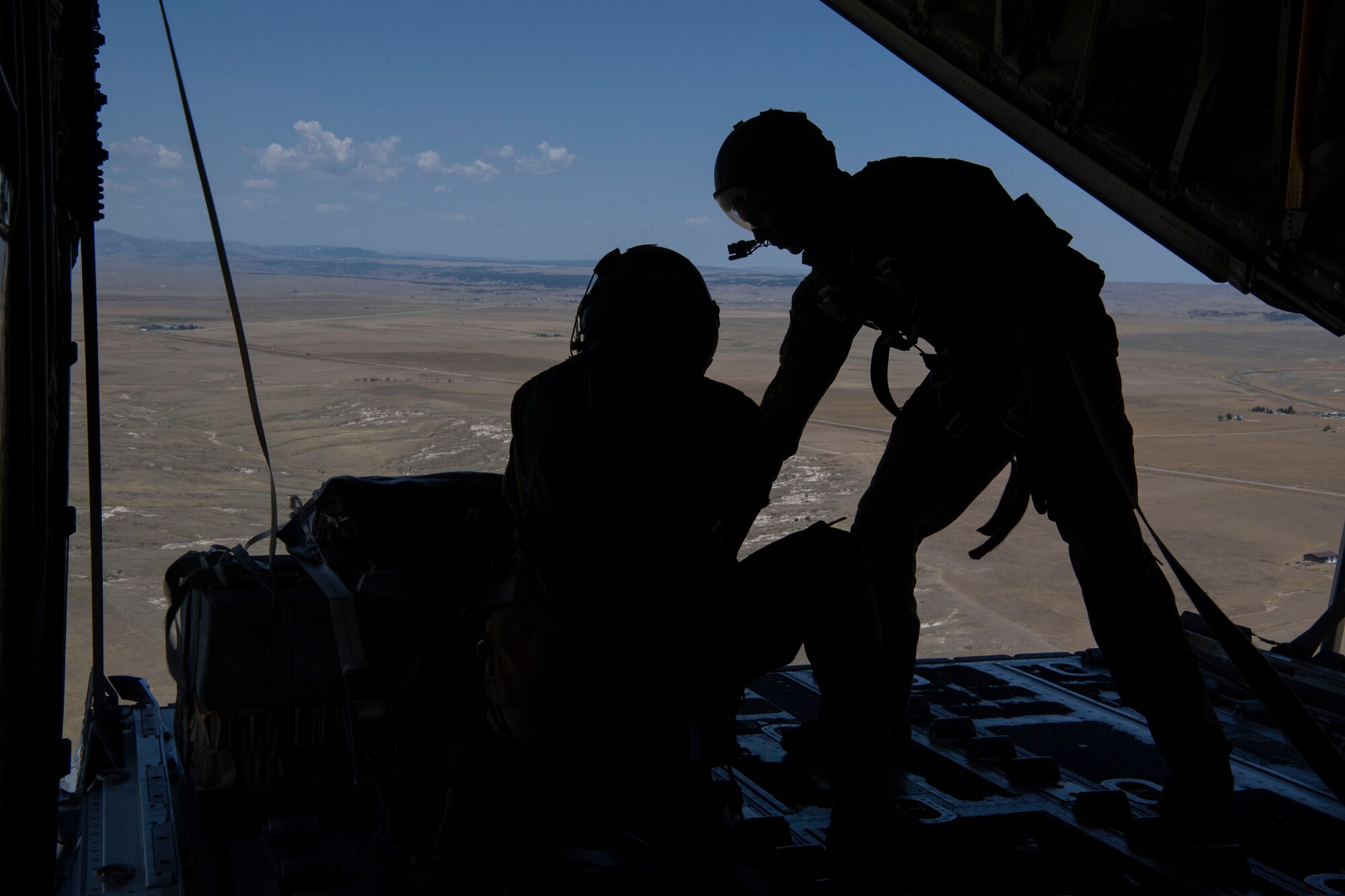 Airman 1st Class Cameron Bou (left) and Senior Airman Kirk Mumau (right), 41st Airlift Squadron loadmasters, conduct an airdrop over Reed Drop Zone in Colorado July 27, 2020. This training is part of the 4/12 deployment initiative, which was developed in 2019 between airlift squadrons from Dyess Air Force Base, Texas and Little Rock AFB, allowing each squadron a full year of dwell time followed by a four-month rotation to their respective area of responsibility. (U.S. Air Force photo by Airman 1st Class Aaron Irvin)