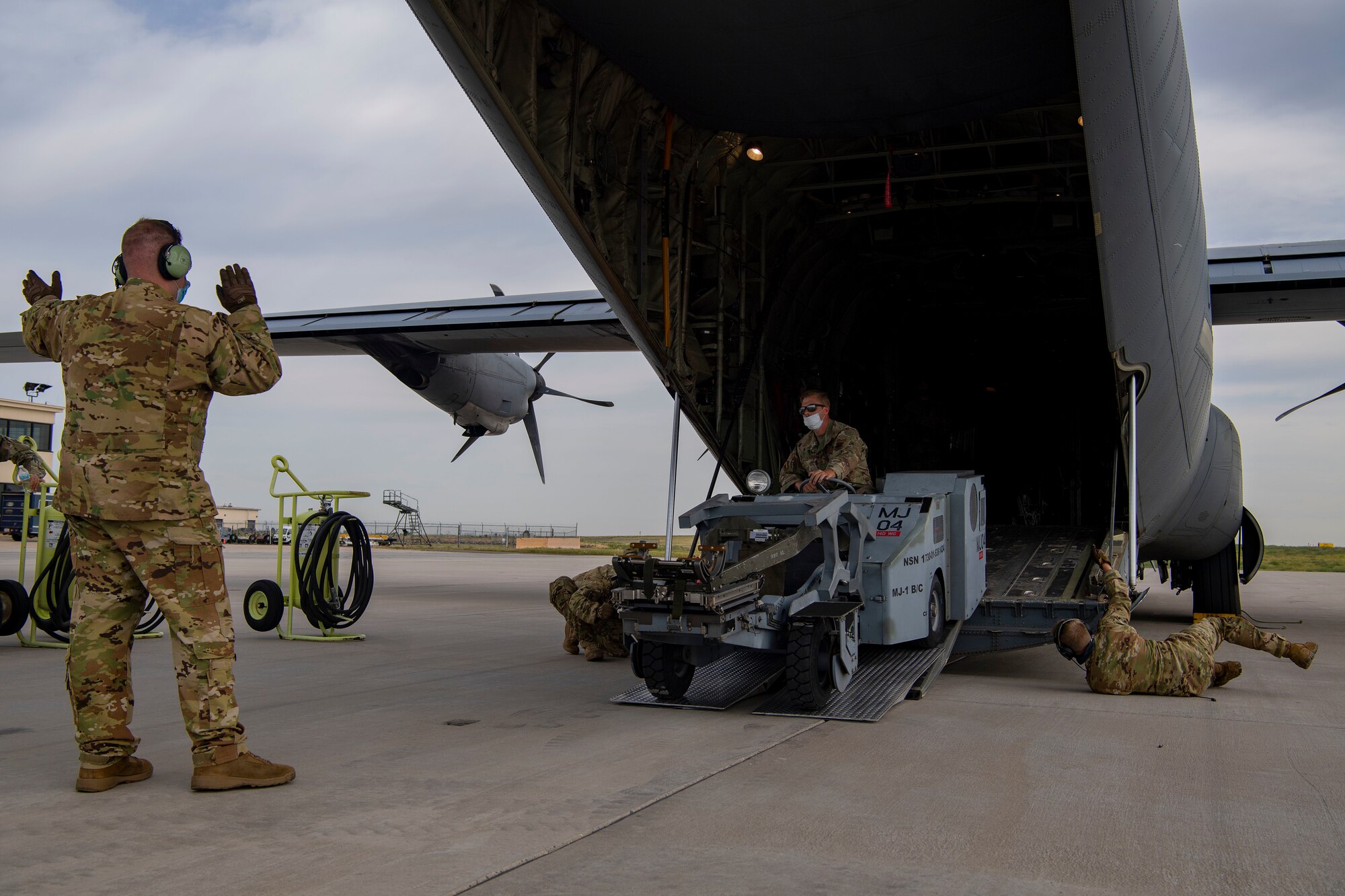 Members from the 41st Airlift Squadron and the 140th Wing, Colorado Air National Guard load cargo onto a C-130J Super Hercules during pre-deployment training at Buckley Air Force Base, Colorado, July 27, 2020. The 4/12 deployment initiative, which was developed in 2019 between airlift squadrons from Dyess AFB, Texas and Little Rock AFB, allowing each squadron a full year of dwell time followed by a four-month rotation to their respective area of responsibility. (U.S. Air Force photo by Airman 1st Class Aaron Irvin)