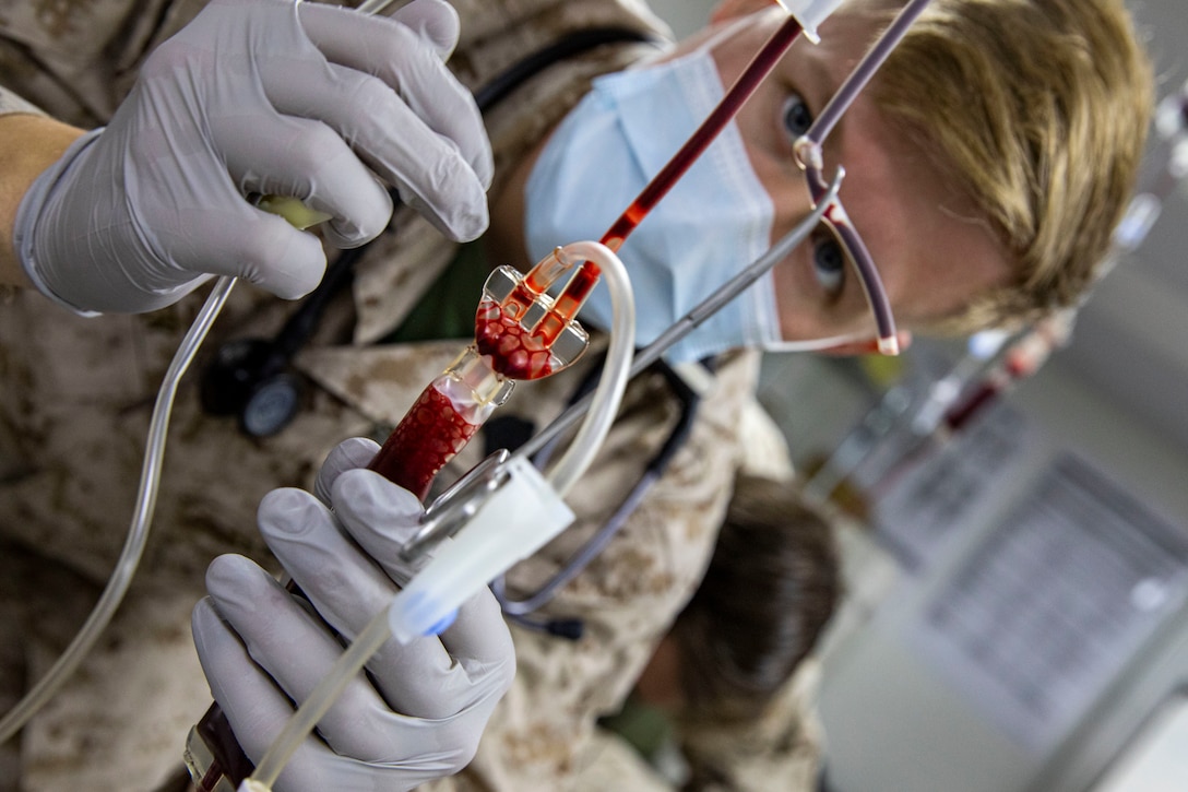 A U.S. Navy hospital corpsman assigned to Special Purpose Marine Air-Ground Task Force - Crisis Response - Central Command 20.2, monitors the flow of blood to a patient during a Valkyrie Emergency Whole Blood Transfusion Training Program in Kuwait.