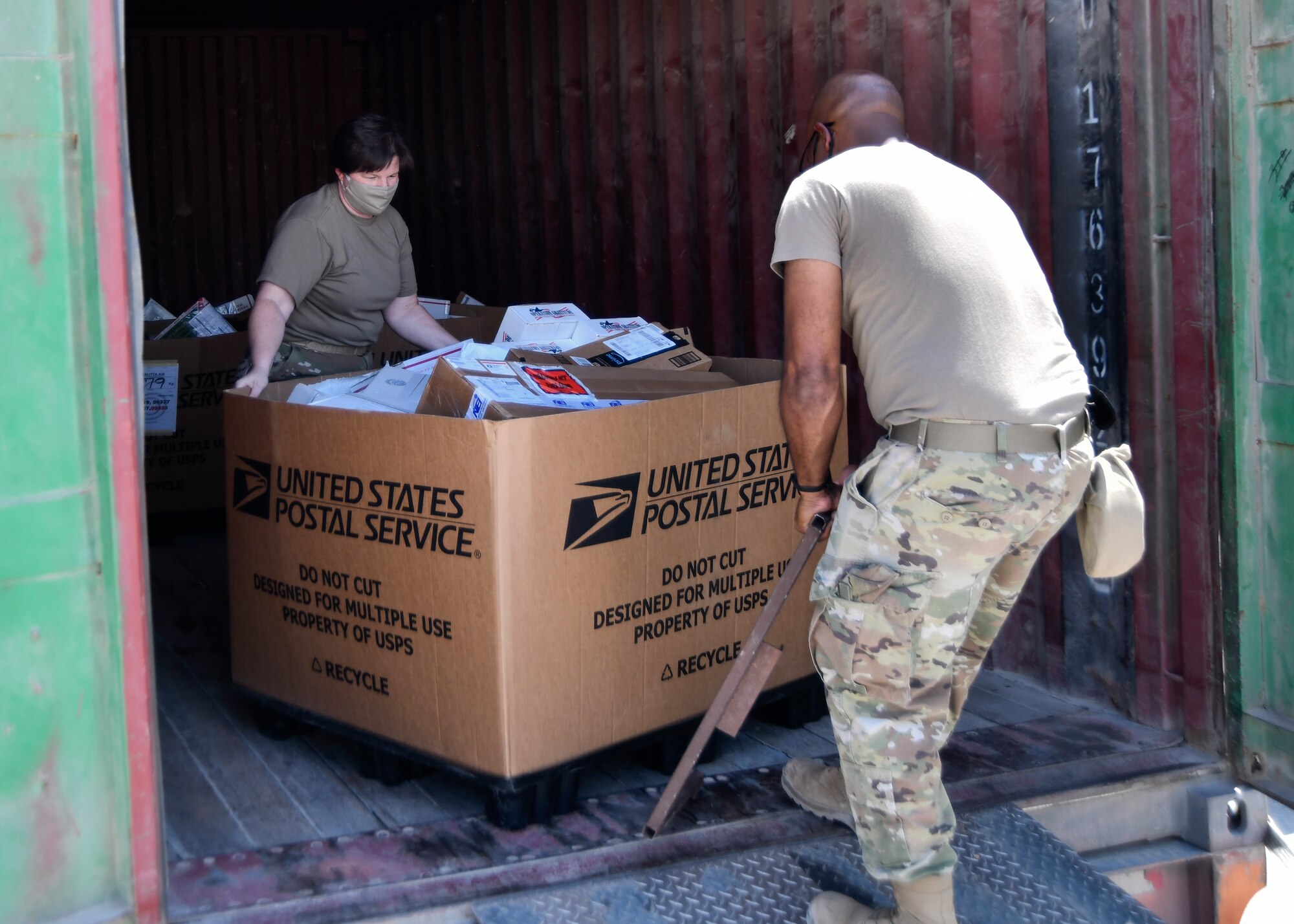 Airmen unload mail from truck