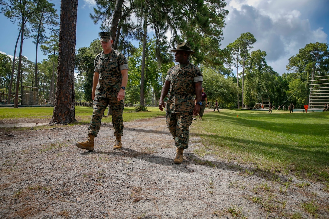 The 19th Sergeant Major of the Marine Corps, Sgt. Maj. Troy E. Black observes recruits attempt obstacles on the confidence course with Depot Sergeant Major, Sgt. Maj. William C. Carter, at Marine Corps Recruit Depot (MCRD) Parris Island, S.C., July 22, 2020. During the visit Sgt. Maj. Black toured the training facilities to observe changes made keep recruits and Drill Instructors safe during COVID-19 restrictions. The changes include the use of face masks when less than six feet apart, and smaller platoon sizes in addition to the 14 days of restriction of movement before new recruits start training. (U.S. Marine Corps photo by Sgt. Victoria Ross)