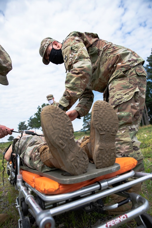 Spc. Vitalii Anchakivskyi of Task Force Illini, 33rd Infantry Brigade Combat Team, Illinois National Guard secures a soldier from Task Force Juvigny in preparation for transport back to the medical clinic located at Collective Training Center- Yavoriv, Ukraine, July 27.