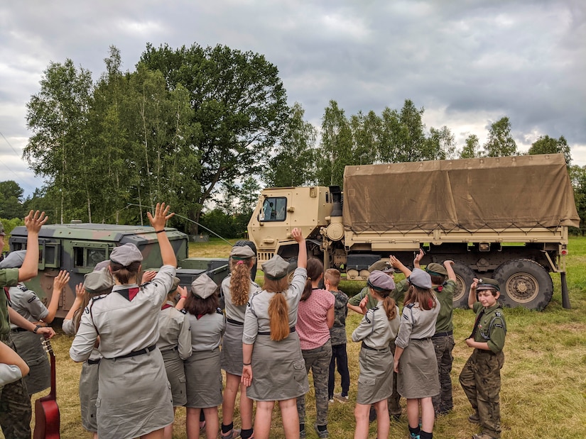 Polish scouts wave farewell to U.S. Soldiers in high-mobility multipurpose wheeled and medium tactical vehicles belonging to the U.S. Army Reserve’s 266th Ordinance Company, out of Puerto Rico, at Camp Watra near Osieczow, Poland, July 17, 2020.