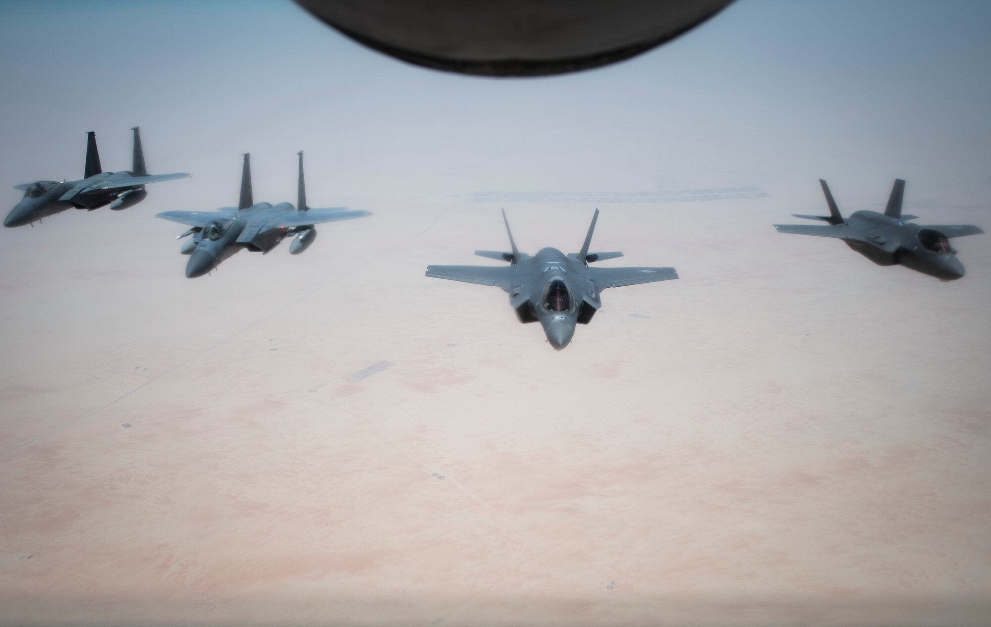 A formation of U.S. Air Forces Central Command F-15C Eagles and F-35A Lightning IIs fly behind a U.S. Air Force KC-135 Stratotanker during air refueling over Southwest Asia, July 25, 2020. Through joint exercises or direct operations, the 380th Air Expeditionary Wing continues to strengthen relationships with regional and coalition partners to defend the region. (U.S. Air Force photo by Master Sgt. Larry E. Reid Jr.)