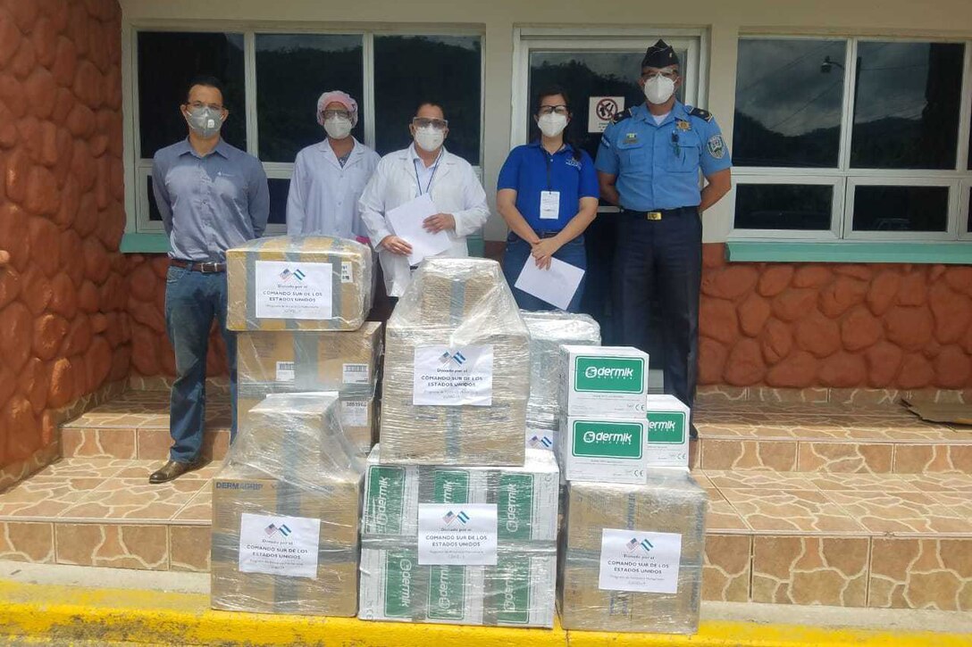 Boxes of supplies sit on stairs in front of a building.