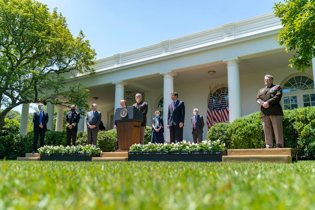 A soldier speaks at a lectern outside the White House as other officials stand by.