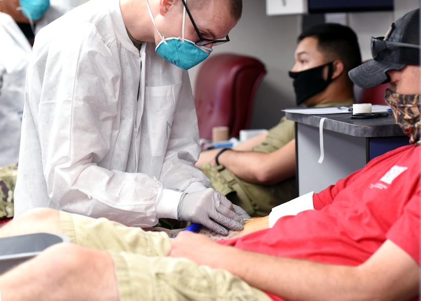 A technician takes a blood donation from a soldier.