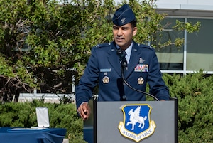 Photo of a man standing behind a podium outside.