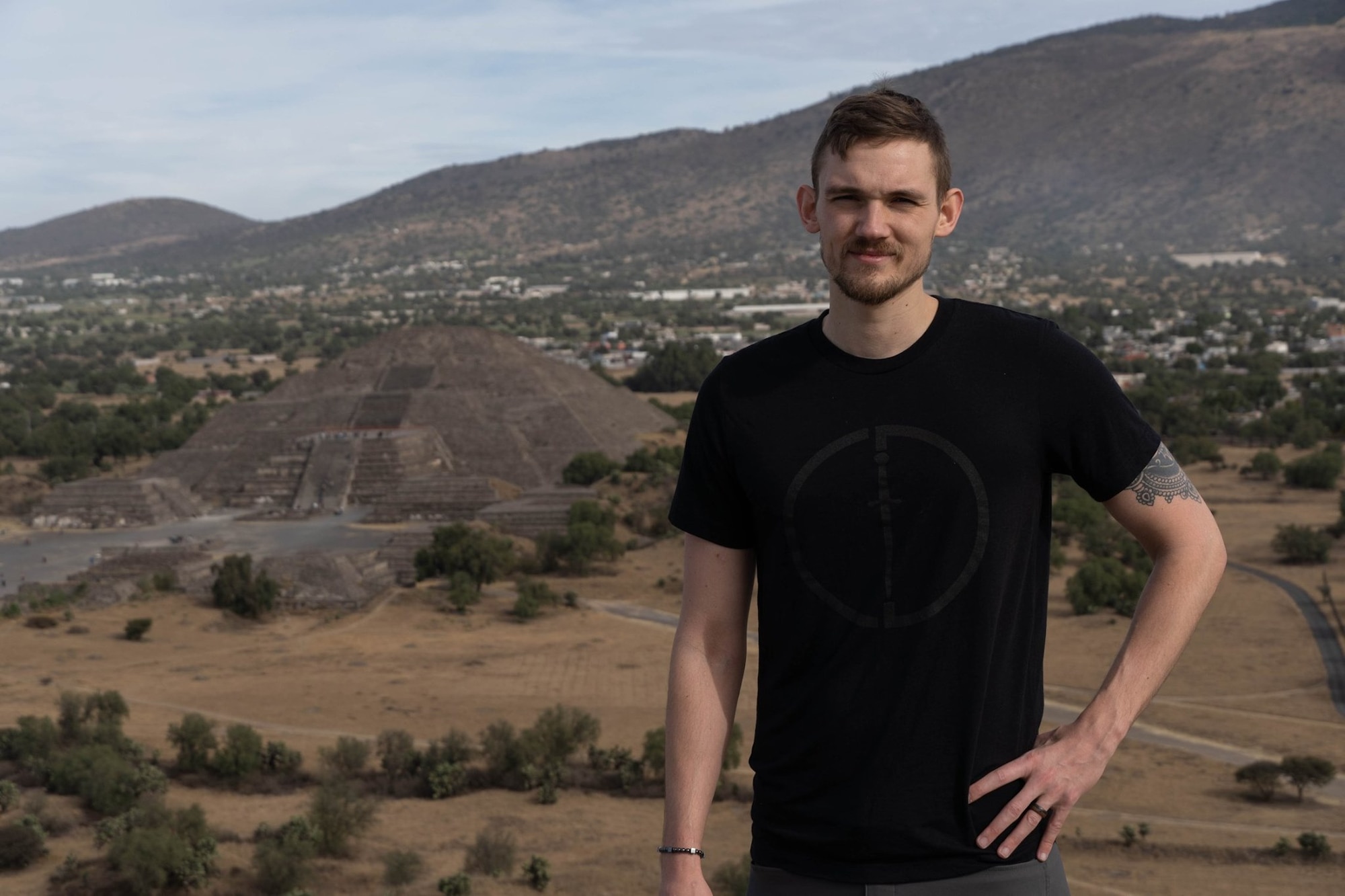 Staff Sgt. Jeffrey Grossi, a photojournalist assigned to the 910th Airlift Wing’s Public Affairs Office, poses in front of the temple of the moon while standing on top of the temple of the sun on Jan. 3, 2020, Teotihuacan, Mexico. Grossi was in Mexico to premiere a Penn State documentary called Land and Water Revisited. The Land and Water Revisited Project aims to document the drastic changes that have occurred to the people and the environment of the Teotihuacan Valley in the last 50 years.