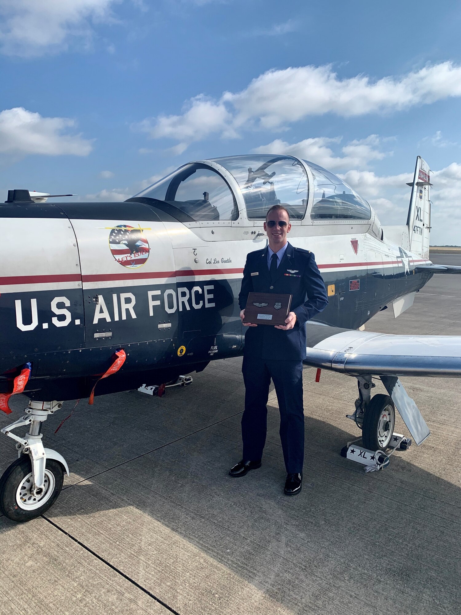 2nd Lt. Max Vickerman holds his undergraduate pilot training course distinguished graduate award on his graduation day, standing by Laughlin Air Force Base’s flagship T-6 aircraft.
