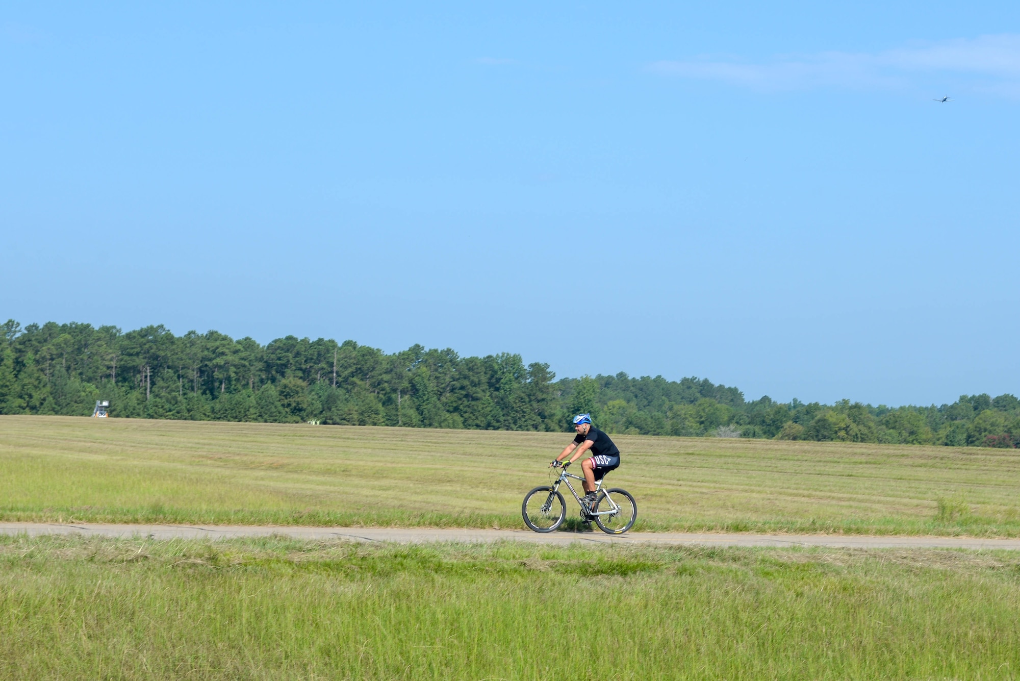 A person rides a bicycle on Perimeter Road on August 5, 2020, at Columbus Air Force Base, Miss. For cardio, Quinten Floyd, Columbus AFB fitness director, suggested base members use the BLAZE Fitness Trail and Perimeter Road. (U.S. Air Force photo by Airman 1st Class Davis Donaldson)