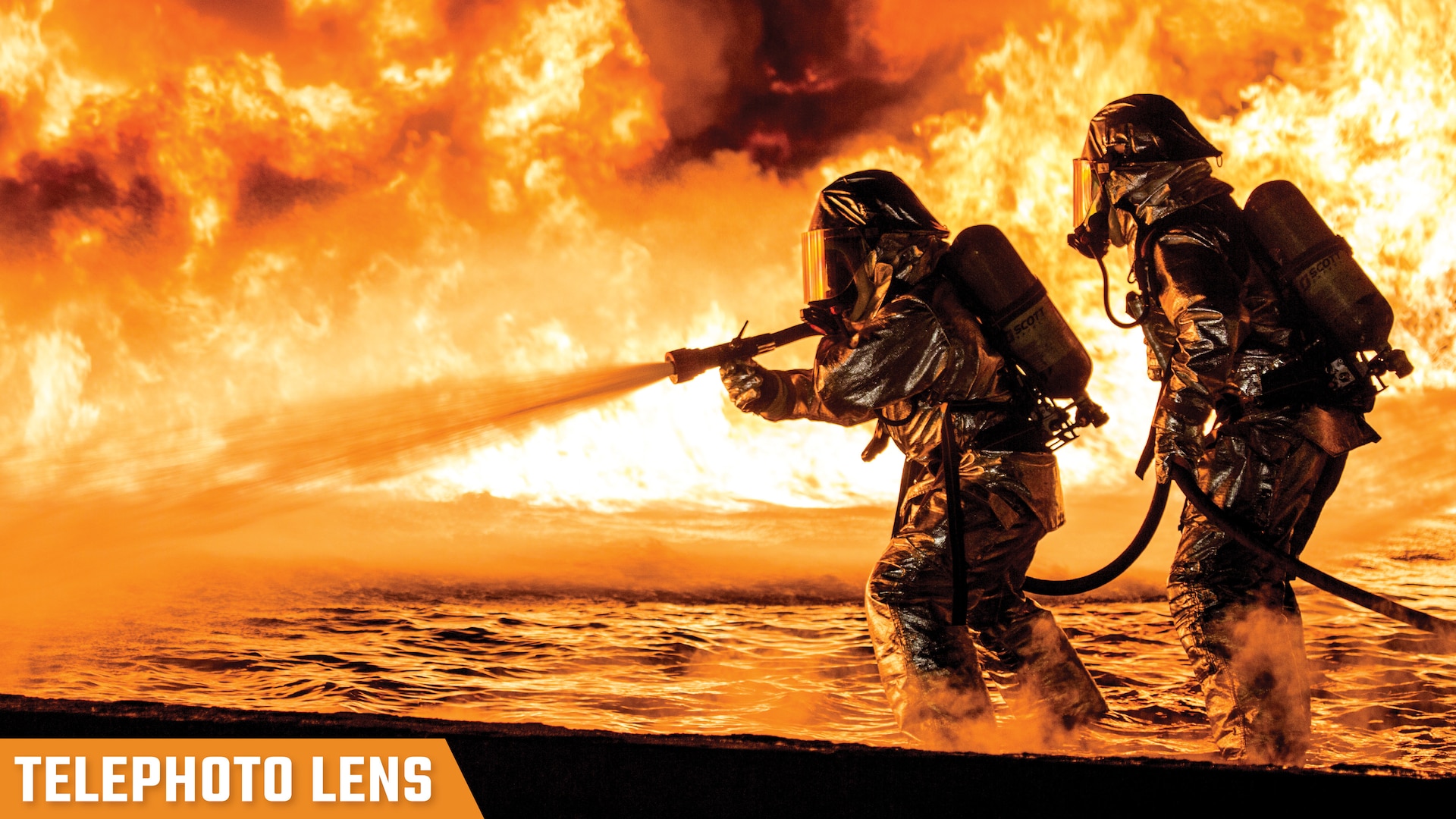 Image of two fire fighters in hazmat suites hosing a fire labeled, "Telephoto Lens."