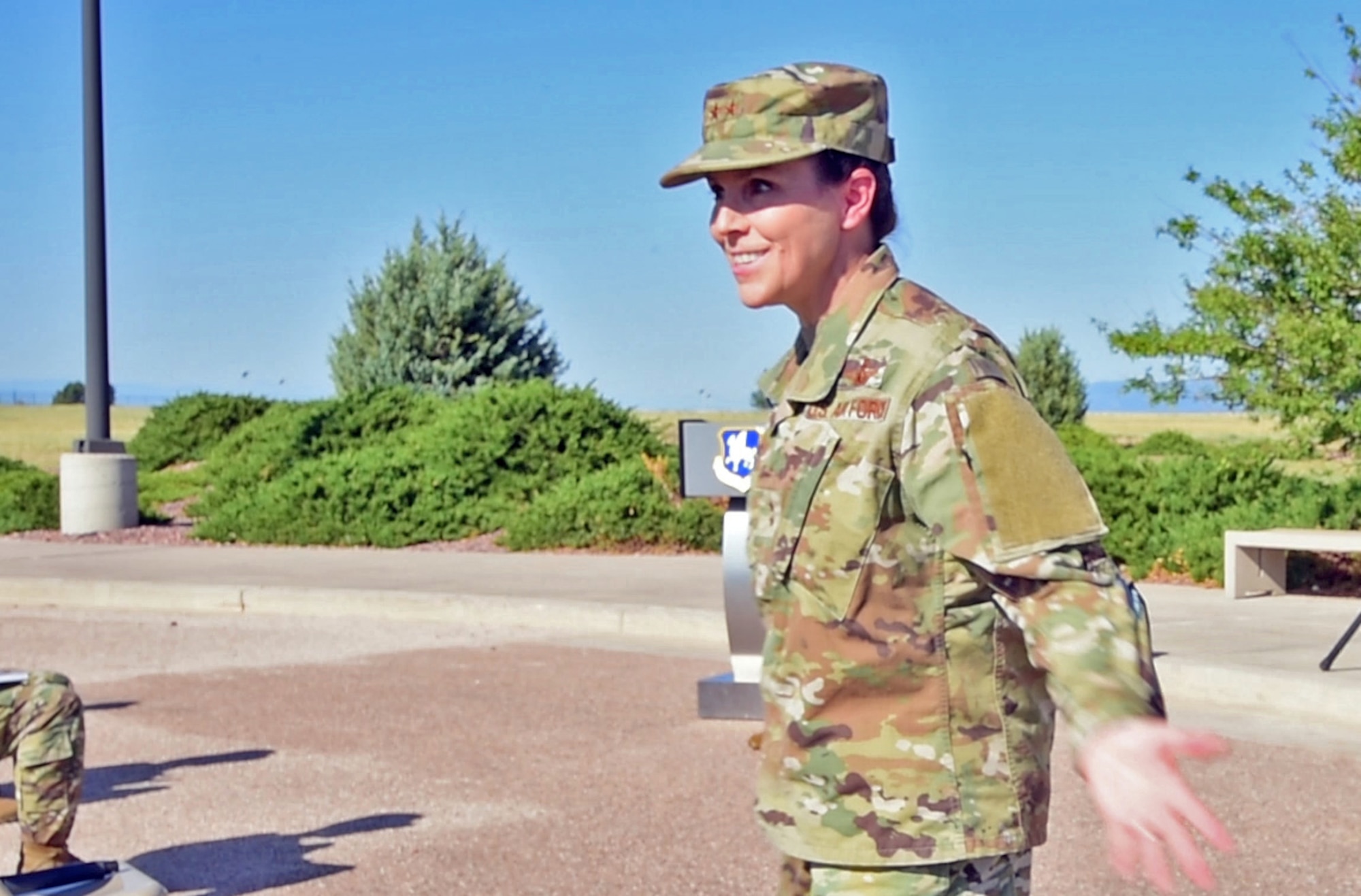 Photo of a woman standing outside with her arms out.