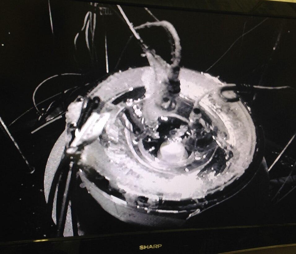 A low light level camera inside the bell jar facility took this photograph during a test at Martian surface pressures and temperature.  In the center is a small dewar of water being held at just above freezing.  Water vapor from this pool quickly freezes on surrounding equipment.  These features closely resemble what is seen in terrestrial Rodriguez wells, improving confidence in the experiment design.