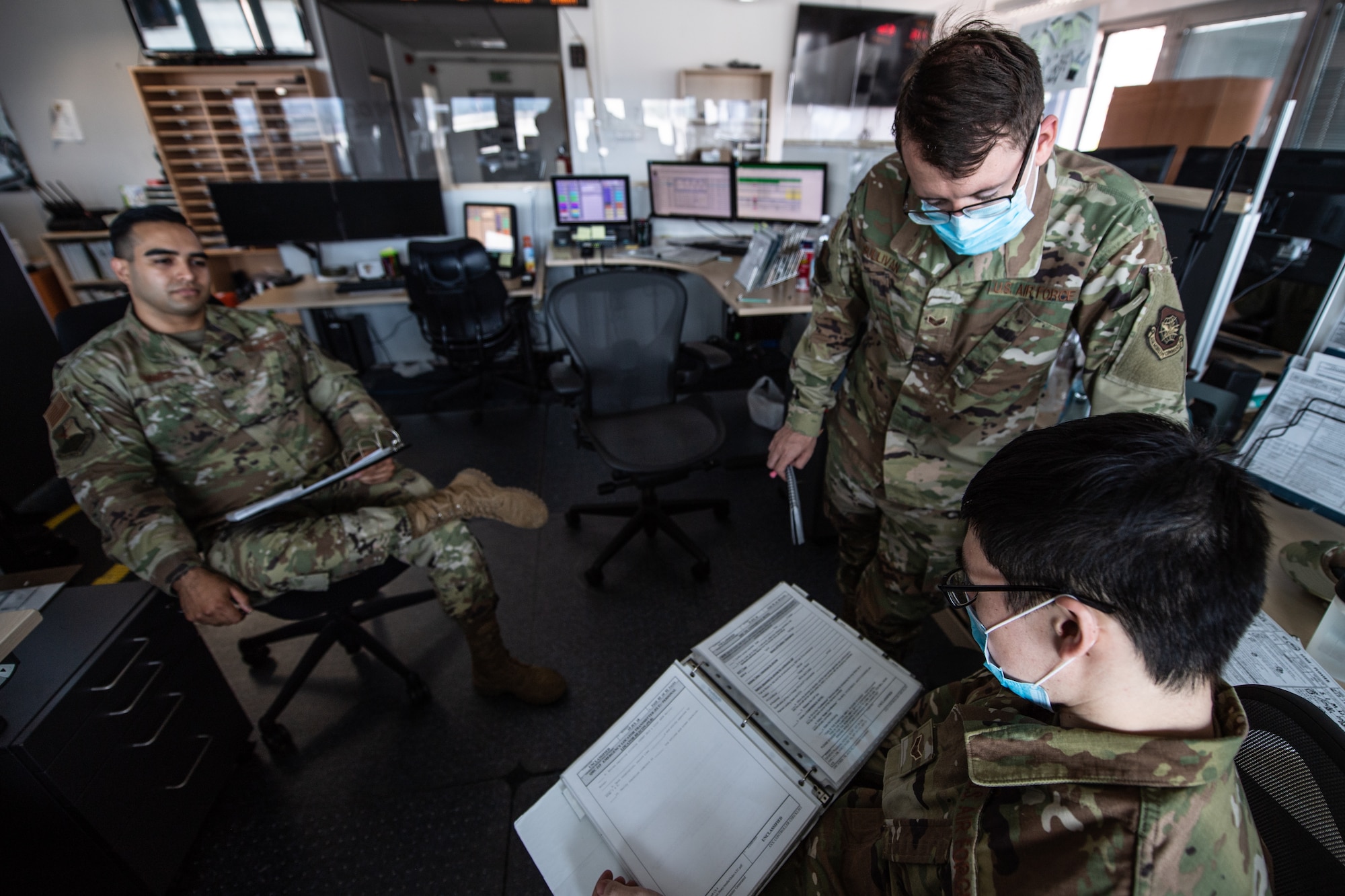 Photo of Airmen having a discussion in an office