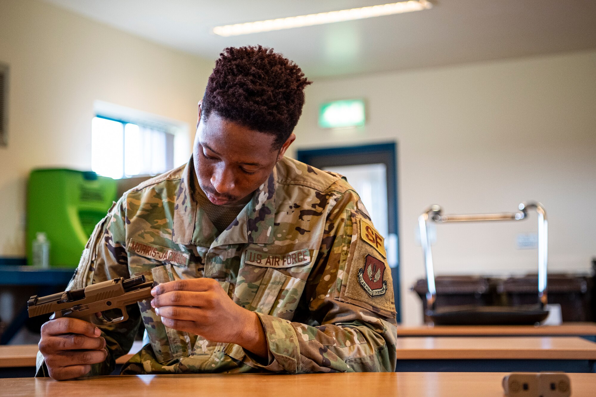 U.S. Air Force Airman 1st Class Shawn Morris-Jackson, 423rd Security Forces Squadron (SFS) armory patrolman, disassembles an M18 handgun during a qualification course at RAF Molesworth, England, July 28, 2020. During the course, Airmen from the 423rd SFS became familiar with the M18 and learned about its various functions and overall benefits such as improved ergonomics, target acquisition, reliability and durability to increase shooter lethality.  The M18 Sig Sauer Modular Handgun System will be replacing the M9 Beretta which has been in use for over 30 years. (U.S. Air Force photo by Senior Airman Eugene Oliver)