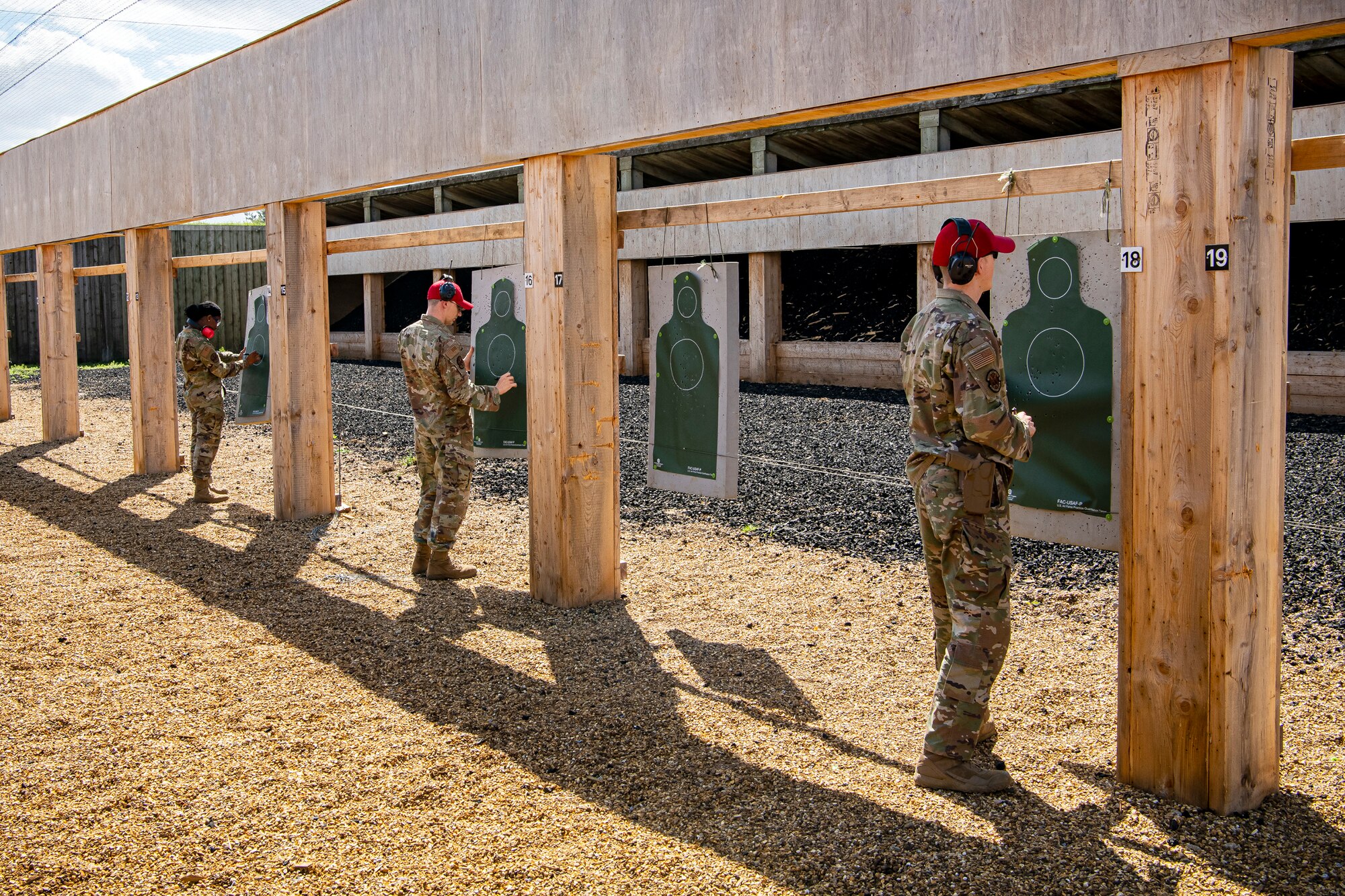 Combat arms training and maintenance (CATM) instructors with the 423rd Security Forces Squadron, score target sheets during a M18 handgun qualification course at RAF Molesworth, England, July 28, 2020. During the course, CATM instructors taught Airmen from the 423rd SFS about the M18 and instructed about its various functions and overall benefits such as improved ergonomics, target acquisition, reliability and durability to increase shooter lethality. The M18 Sig Sauer Modular Handgun System will be replacing the M9 Beretta which has been in use for over 30 years. (U.S. Air Force photo by Senior Airman Eugene Oliver)