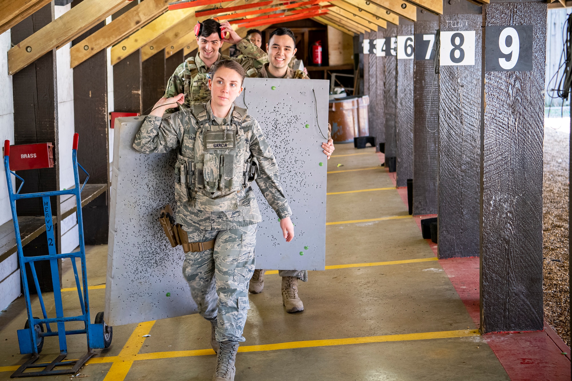 U.S. Air Force Airmen from the 423rd Security Forces Squadron (SFS) carry their target sheets during an M18 handgun qualification course at RAF Molesworth, England, July 28, 2020. During the course, Airmen from the 423rd SFS became familiar with the M18 and learned about its various functions and overall benefits such as improved ergonomics, target acquisition, reliability and durability to increase shooter lethality.  The M18 Sig Sauer Modular Handgun System will be replacing the M9 Beretta which has been in use for over 30 years. (U.S. Air Force photo by Senior Airman Eugene Oliver)