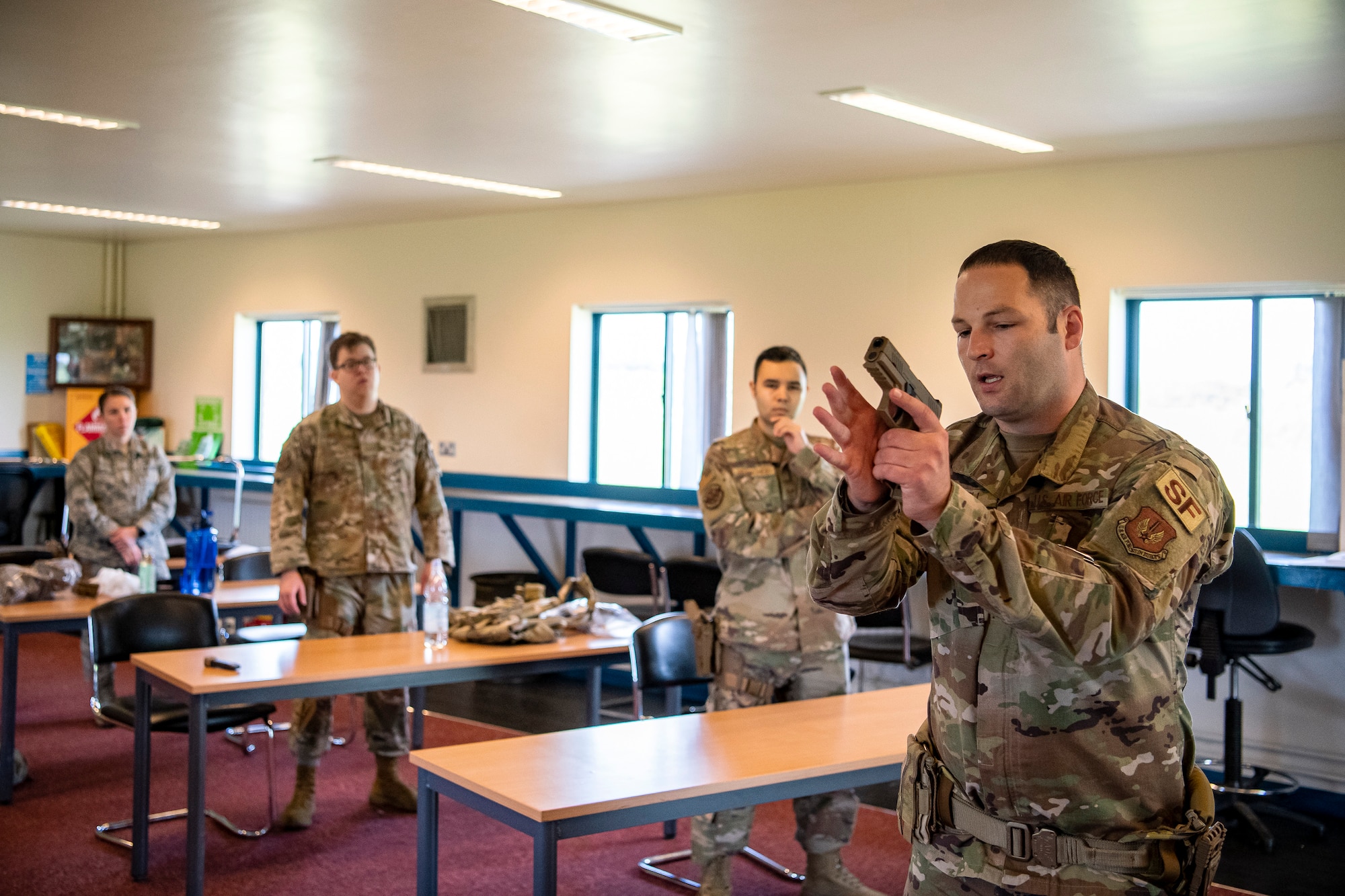 U.S. Air Force Staff Sgt. Kevin Campbell, right, 423rd Security Forces Squadron (SFS) noncommissioned officer in charge of combat arms training and maintenance, instructs Airmen from the 423rd SFS during a M18 handgun qualification course at RAF Molesworth, England, July 28, 2020. During the course, Airmen from the 423rd SFS became familiar with the M18 and learned about its various functions and overall benefits such as improved ergonomics, target acquisition, reliability and durability to increase shooter lethality. The M18 Sig Sauer Modular Handgun System will be replacing the M9 Beretta which has been in use for over 30 years. (U.S. Air Force photo by Senior Airman Eugene Oliver)