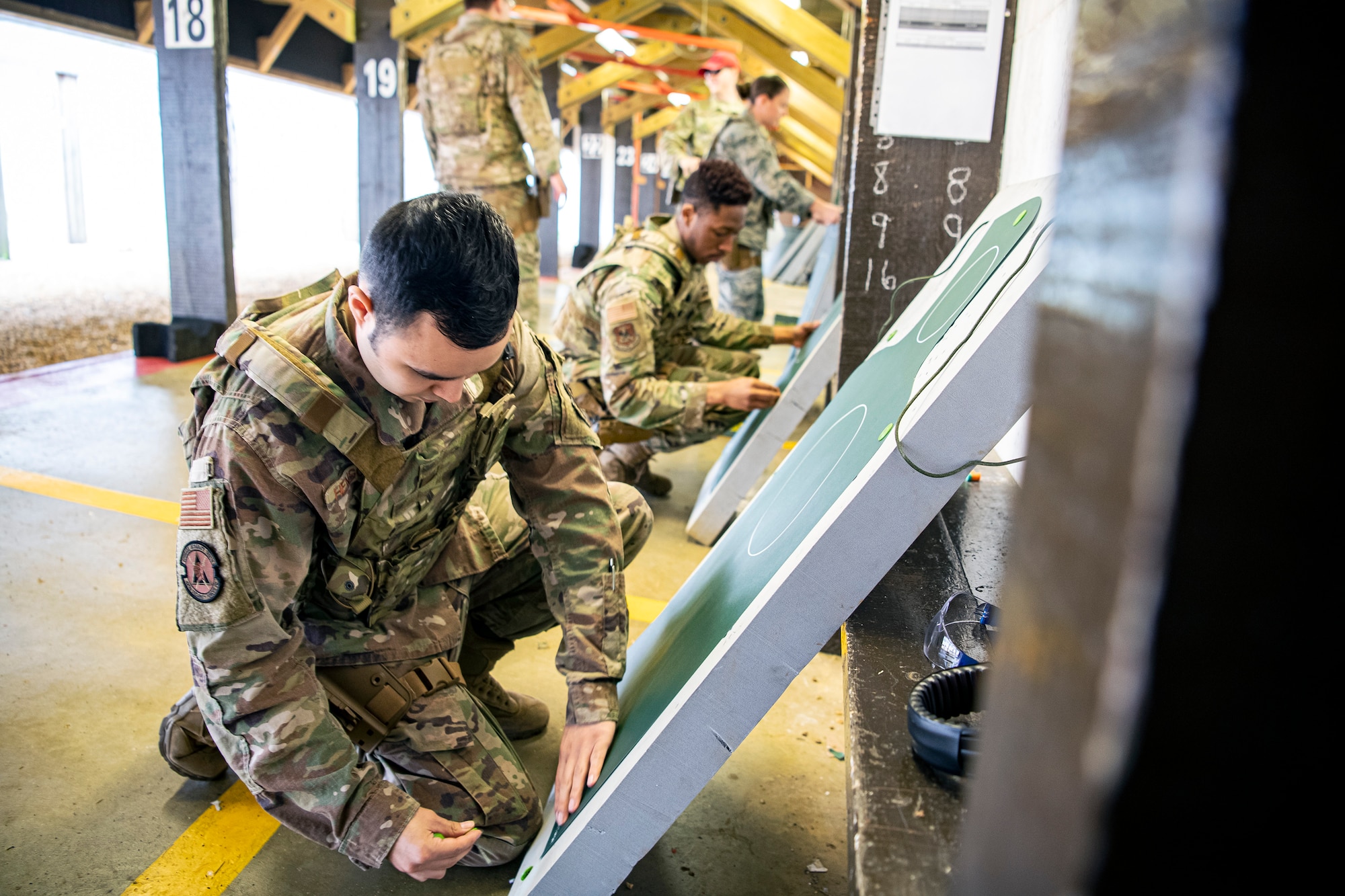 U.S. Air Force Airmen from the 423rd Security Forces Squadron (SFS) set up their target sheets during an M18 handgun qualification course at RAF Molesworth, England, July 28, 2020. During the course, Airmen from the 423rd SFS became familiar with the M18 and learned about its various functions and overall benefits such as improved ergonomics, target acquisition, reliability and durability to increase shooter lethality.  The M18 Sig Sauer Modular Handgun System will be replacing the M9 Beretta which has been in use for over 30 years. (U.S. Air Force photo by Senior Airman Eugene Oliver)