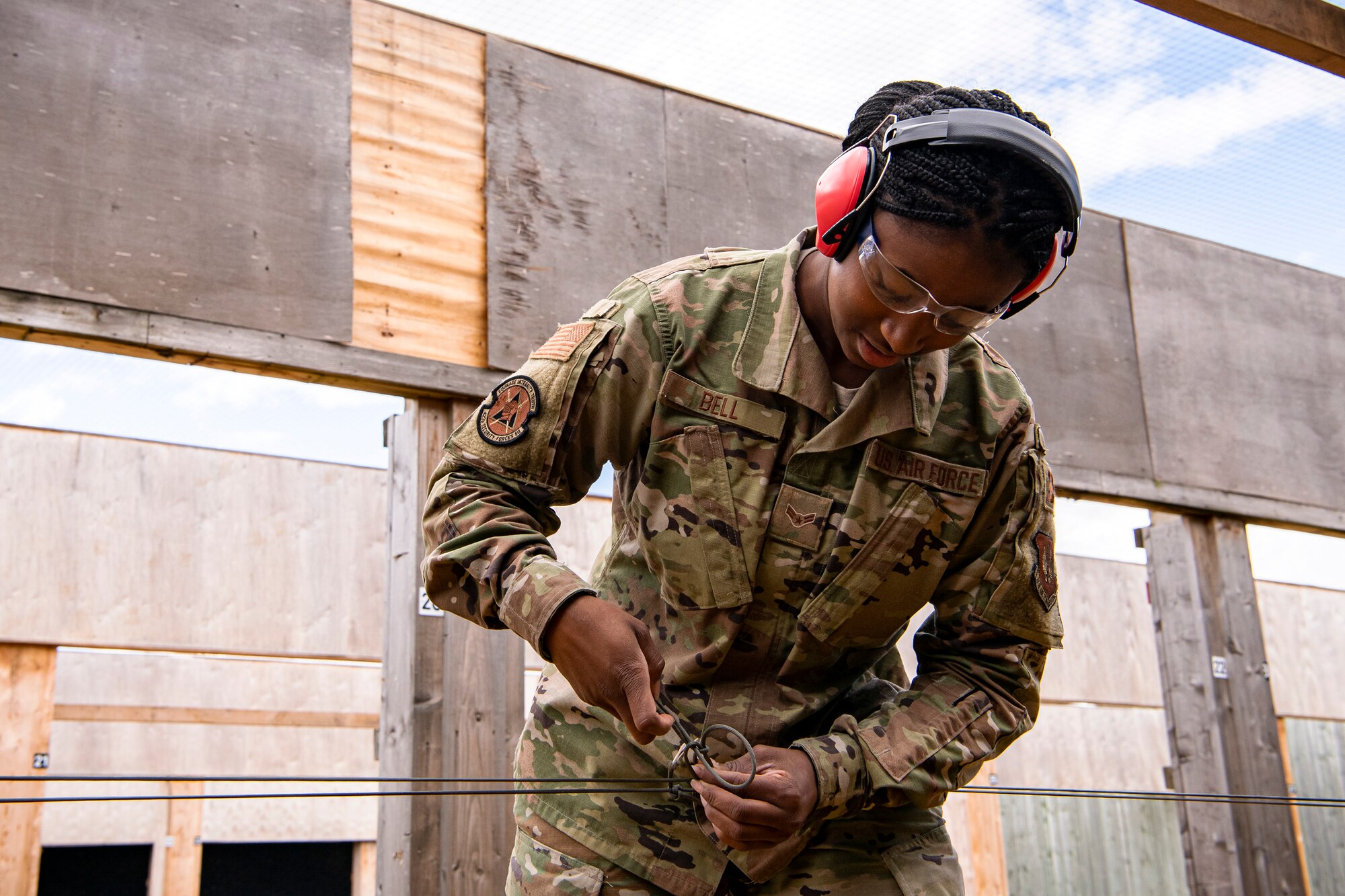 U.S. Air Force Airman 1st Class Keh-Turrah Bell, 423rd Security Forces Squadron (SFS) combat arms training and maintenance (CATM) instructor in training, ties together a 550 cord during a M18 handgun qualification course at RAF Molesworth, England, July 28, 2020. During the course, CATM instructors taught Airmen from the 423rd SFS about the M18 and instructed about its various functions and overall benefits such as improved ergonomics, target acquisition, reliability and durability to increase shooter lethality. The M18 Sig Sauer Modular Handgun System will be replacing the M9 Beretta which has been in use for over 30 years. (U.S. Air Force photo by Senior Airman Eugene Oliver)