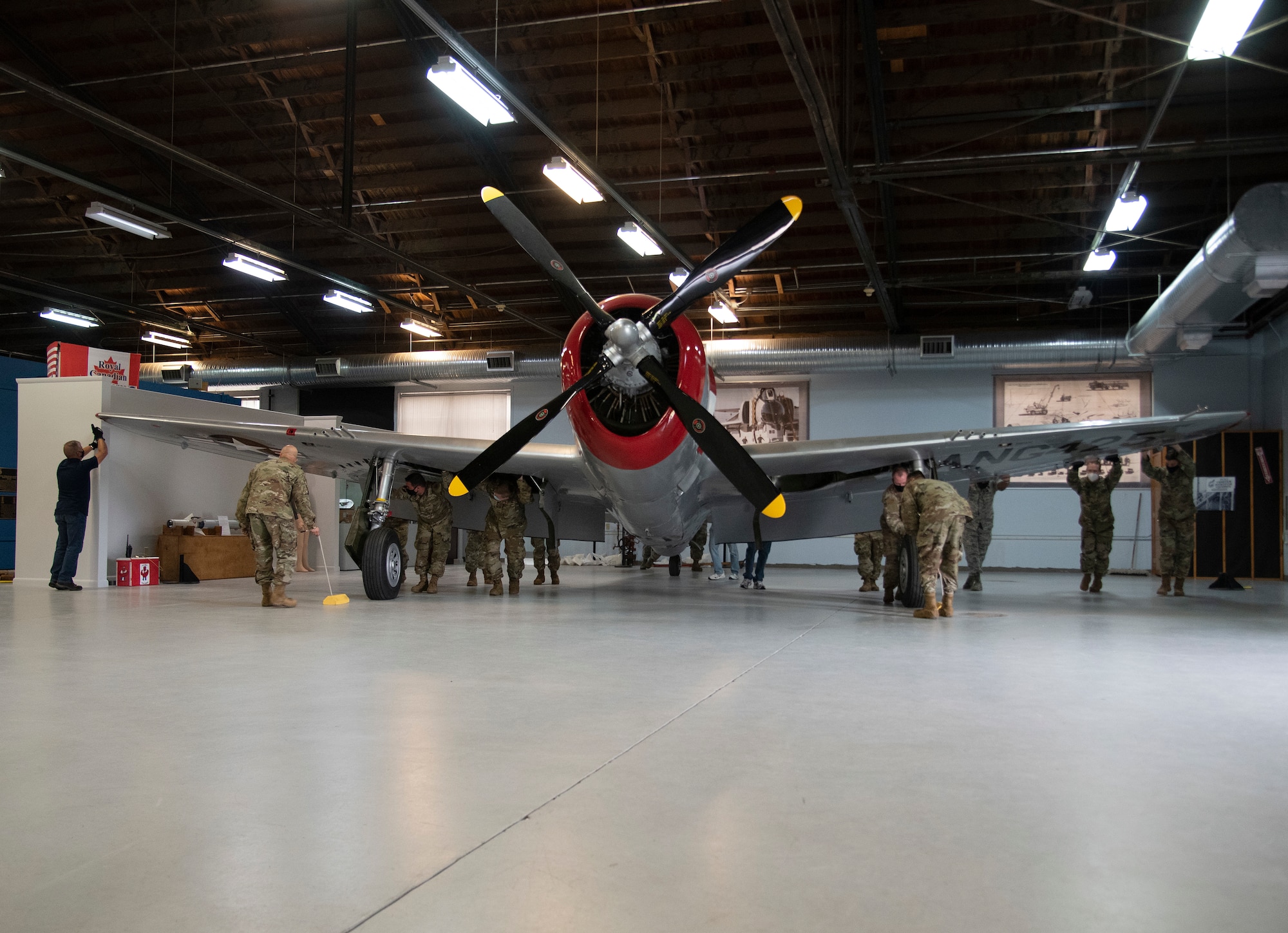 Photo of Airmen pushing aircraft by hand