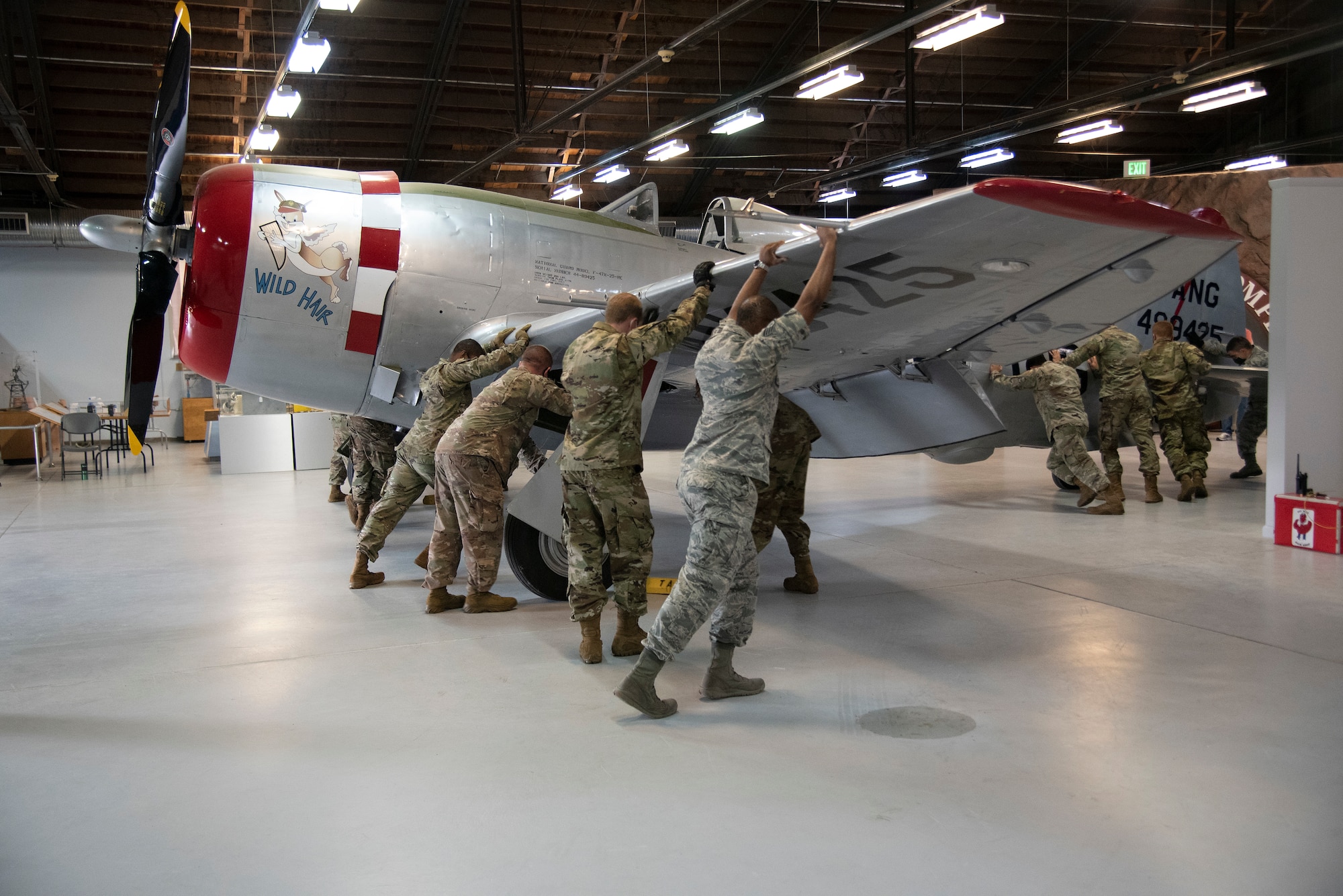 Photo of Airmen pushing an aircraft by hand