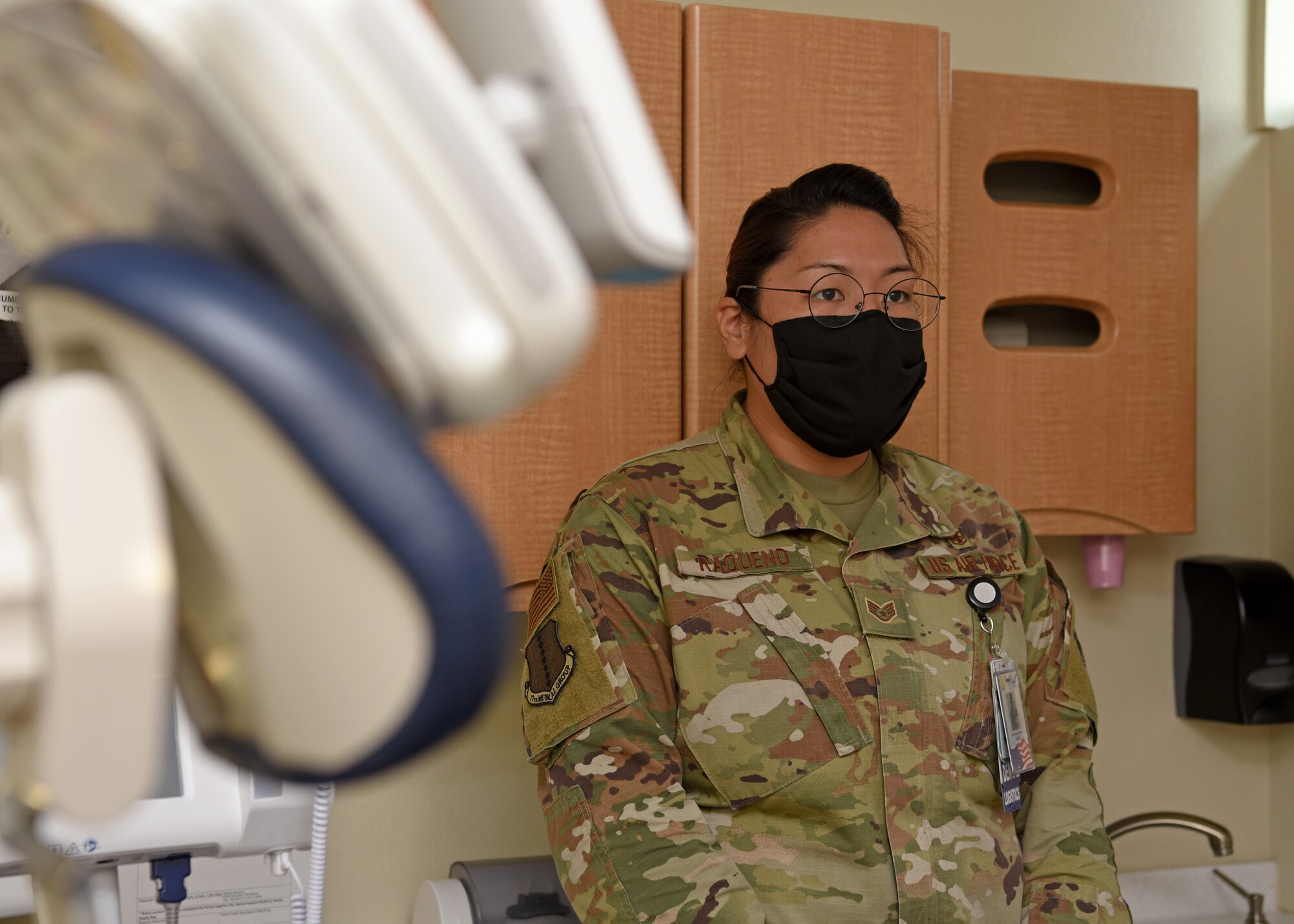 U.S. Air Force Staff Sgt. Sydney Raqueno, 17th Operations Medical Readiness Squadron, dental logistics NCO in charge, stands in a dental exam room and explains how the dental clinic evolves through the COVID-19 pandemic, at the Ross Clinic’s dental facility, on Goodfellow Air Force Base, Texas, Aug. 5, 2020.  Raqueno wore a mask and maintained a social distance throughout the clinic. (U.S. Air Force photo by Airman 1st Class Abbey Rieves) Note: this photo has been edited to blur a medical badge.