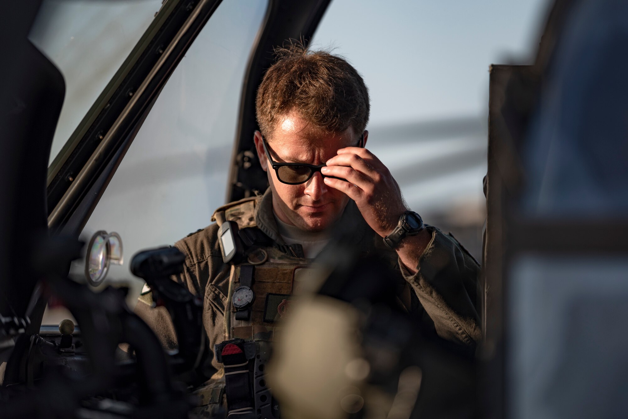 A photo of an Airman sets equipment in a helicopter before a flight