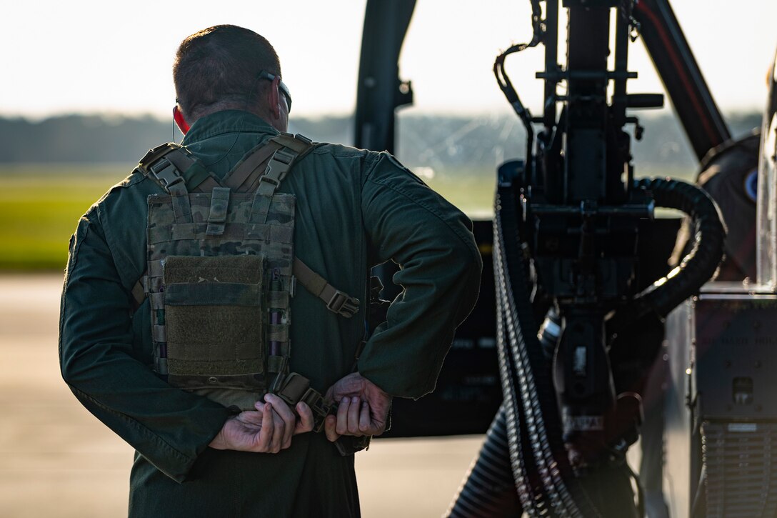 A photo of an Airman putting on a vest before a flight